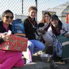 Volunteers give Holiday Pet Basket to man and his dog.