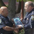 Photo: UC Davis police officer Walter Broussard receives a plaque from Police Chief Matt Carmichael, in memory of K-9 officer Grimm.