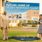 Dignitaries flank sign designationg "future Home of UC Davis Rehabilitation Hospital."