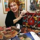 picture of Victoria Rivers surrounded by materials and catalogs.