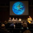 Roundtable panelists under slide of the earth.