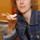 Photo: woman holding bird figure with saccharine bottle in foreground