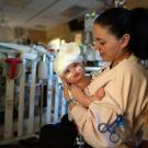 Woman holds baby in hospital.