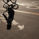 A student's shadow is seen on a bike path.