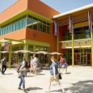 Outside of a two story building with sgn that says Student Community Center and several students walking in front