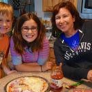 Susan Rivera and her two children making pizza at home