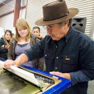 Photo: Malaquias Montoya demonstrating silk screening