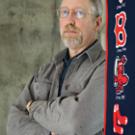 Historian Alan Taylor stands next to a Boston Red Sox banner (he is a Sox fan). Each spring Taylor helps graduate students organize a weekly game of town ball, an early 19th century baseball-style game that he learned about while doing research 