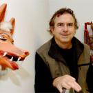 Ed Taylor stands amid souvenirs representative of his many travels throughout the world. His studies include international migration, rural economies and how economics impacts the environment.  