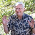 Tom Cahill, smiling, throwing hands up, at riparian preserve donation, May 2017.