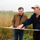 Viticulture and enology professor Andy Walker, left, and campus landscape architect Skip Mezger review the site plan for the 14.5-acre vineyard that will be planted between where they are standing and the Robert Mondavi Institute behind them.