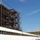 Photo: steel girders of a new building next to an existing two-story building