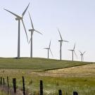 Photo: Wind turbines on a hill with a rural fence in foreground