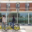 Two students standing outside of Memorial Union on a sunny day