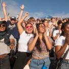 A diverse group of smiling young people outdoors in sunshine 