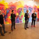 Artists stand in front of mural.