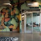 People talk outside of a brightly decorated office labeled "connect labs by WEXFORD" 