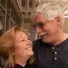 A smiling couple gazing into each other’s eyes, enjoying a joyful moment together.