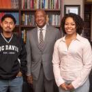 Three people stand in an office