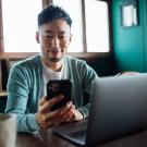 portrait of man looking at phone with window and door behind him