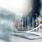 Illustration of buisness and finance data; man in blue jacket looking at data on digital platforms