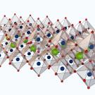 3D structural representation of a crystalline lattice with colored spheres and tetrahedra.