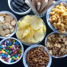 In this episode of Unfold, we uncover the science and debate behind processed and ultra-processed foods. Shown here are eight bowls with various processed and ultra-processed foods, including chips, pretzels and candies.(Getty)