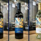 Three wines that are part of the Hilgard631 collection, including two UC Davis cabernet sauvignons and a sauvignon blanc. The wines are on a table and feature multi-colored labels that show the UC Davis water tower and Robert Mondavi Institute buildings.(Jael Mackendorf / UC Davis)
