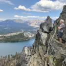 Hugh Safford overlooks Echo Lake. He stands with arms folded along rocky ridges. The lake is below and mountains are int backdrop.