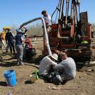 UC Davis researchers insert a long tunnel-like device into the ground of a unplanted farm field. The device continuously collects water samples underground, providing real-time data on nitrate contaminant movement. (Isaya Kisekka / UC Davis)