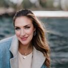 Woman sits in front of a blurry background