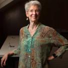 Johanna Schmitt  leans against a staircase inside a building.