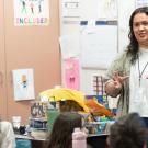 College student stands in front of a class at an elementary school