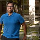 Man leans against a table in an outdoor patio