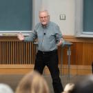 Steven Luck stands with arms wide as he teaches in a class