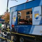 Three people are seated in the Cal OES shake trailer