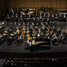 symphony orchestra on stage in darkened theater