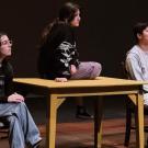 Students on a stage rehearsing play