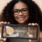 Student Natasha Bibbs holds a framed key to the city of Donaldsonville, Louisiana, in front of her