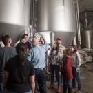 Class gathers around brewing equipment (two giant tanks).