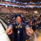 Chancellor Gary S. May poses for a photo with graduates at a commencement ceremony in Golden 1 Center