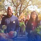 Chancellor May and a student participate in a garden cleanup