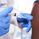 Person wearing gloves administers flu shot