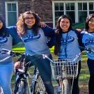 Four female students, posing, on bikes.