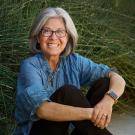 Woman sits in front of plants.