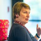 Joanna Regulska, hands outstretched in front of her, leads a seminar.