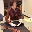 Adele Zhang, senior continuing lecturer, prepares a recently donated garment to be added to the Design Collection at UC Davis. (Maria Sestito/ UC Davis)