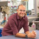 Steven Lucero posing for photo in lab with lots of machinery.