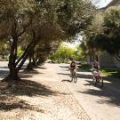 Two bicyclists ride along path adjacent to Russell Boulevard.