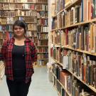 Student standing between library stacks at UC Davis. 